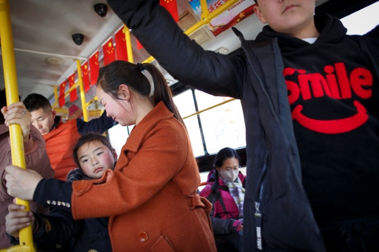 河南省洛陽市でバスに乗る人々