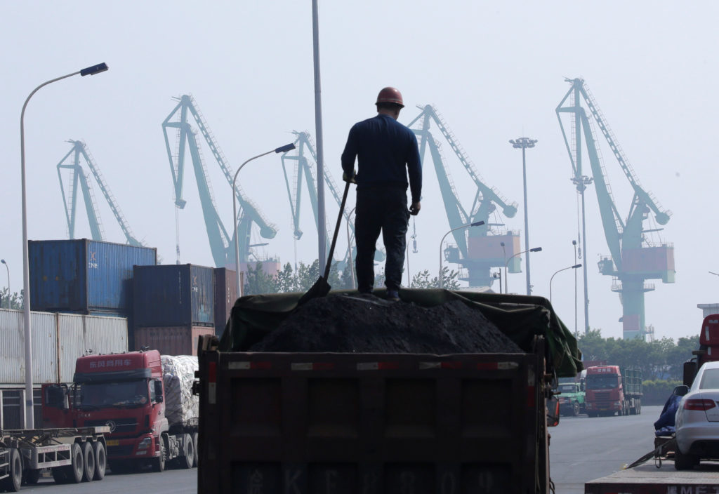 天津港近くの物流施設で石炭を積み込む労働者。