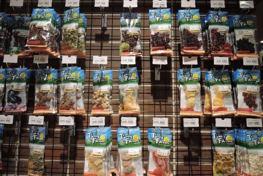 フードウェイソコラ武蔵小金井クロス店では、吊り下げ什器を使用し、プルーンやイチジク、カットパインなどのドライフルーツの手軽さを訴求する