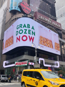 クリスピー・クリーム・ドーナツの店舗と電光掲示板に表示されたドーナツの宣伝