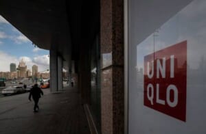 ロシアの閉店したユニクロ店舗の前を通り過ぎる男性
