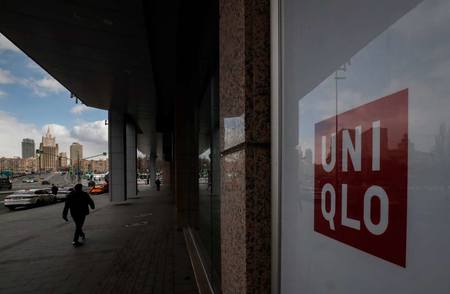 ロシアの閉店したユニクロ店舗の前を通り過ぎる男性