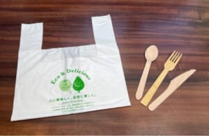すかいらーくの持ち帰り・宅配用のバイオマスプラスチック製のレジ袋と竹製フォーク、木製スプーンとナイフ