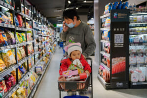中国・北京のスーパーで、買い物をする親子連れ