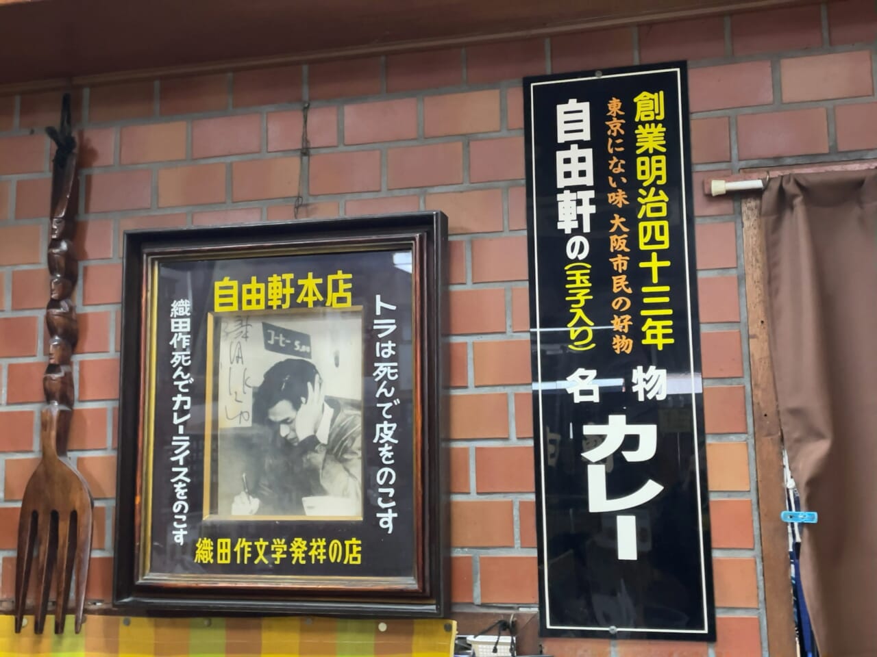 額縁には「織田作文学発祥の店」「織田作死んでカレーライスをのこす」とある