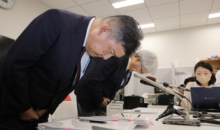 消費期限偽装問題について記者会見し、頭を下げるミニストップの堀田昌嗣社長（左）とイオンの渡辺広之副社長